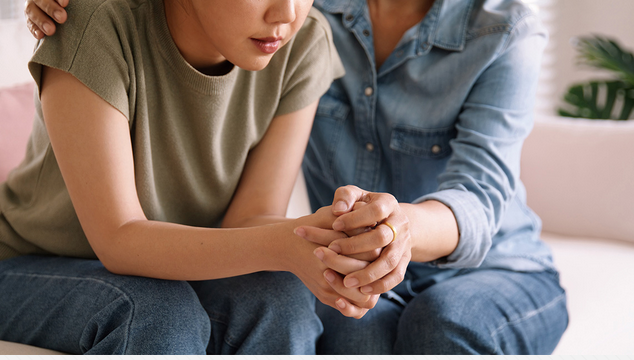 Adult comforting a teenager in distress
